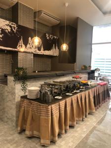 a kitchen with a long table with dishes on it at Ayothaya Hotel in Phra Nakhon Si Ayutthaya