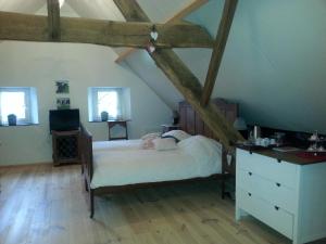 ein Schlafzimmer mit einem Bett und einer Kommode im Dachgeschoss in der Unterkunft B&B La Rue de France in Sevenum