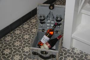 una cesta con botellas de vino y copas en el suelo en B&B La Rue de France, en Sevenum
