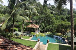 a view of a resort with a swimming pool and palm trees at The Spice House Mirissa in Mirissa