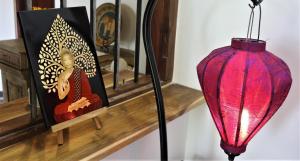 a red lamp sitting on a shelf next to a picture at The Spice House Mirissa in Mirissa