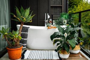una vasca da bagno seduta su un balcone con piante di Wharf Retreat Unit 2 a Tauranga