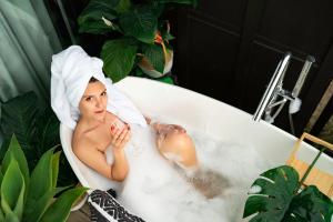 Eine Frau in einer Badewanne mit einem Handtuch auf dem Kopf. in der Unterkunft Wharf Retreat Unit 2 in Tauranga