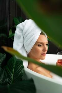 a woman with a towel on her head sitting in a bathtub at Wharf Retreat Unit 2 in Tauranga
