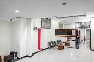 Agnes Residence near Blok M Mitra RedDoorz في جاكرتا: غرفة معيشة بجدران بيضاء وباب احمر