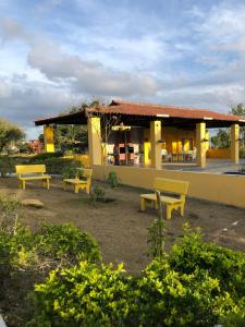 eine Gruppe gelber Bänke vor einem Gebäude in der Unterkunft Flat no Condomínio Paraíso Serra Negra - A 200m da Bodega de Véio in Bezerros