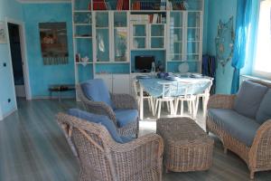 ein Wohnzimmer mit einem Tisch und Korbstühlen in der Unterkunft Villa Marina in Orosei