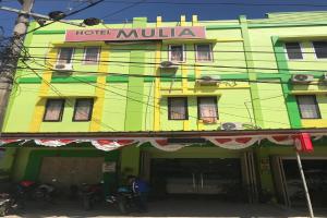 a green building with a hotel muhla sign on it at Hotel Mulia Kendari Mitra RedDoorz in Pipulu