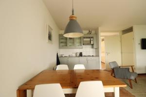 a dining room with a wooden table and white chairs at Vakantiewoningen Ons Krijtland in Epen