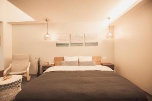 a bedroom with a large bed and a chair at Monoka Hotel Ginza in Tokyo