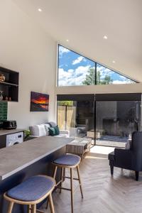 ein Wohnzimmer mit einem großen Fenster und 2 Stühlen in der Unterkunft Magic On Maryburn - The Green Room in Twizel
