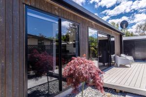 a house with large glass windows on a deck at Magic On Maryburn - The Green Room in Twizel