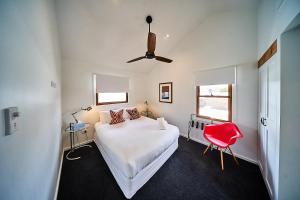 a bedroom with a bed and a red chair at The Signature Lofts in Morpeth