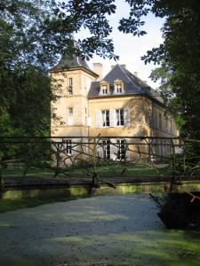 un gran edificio con un puente sobre un río en Les chambres de Preisch en Évrange