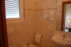 チェルヴィアにあるHotel Massimoのバスルーム(洗面台、トイレ、鏡付)