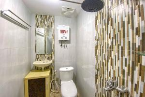 un bagno con wc, lavandino e doccia di Tini's Guest House Malang Mitra RedDoorz a Betek