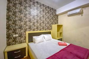 Postel nebo postele na pokoji v ubytování Tini's Guest House Malang Mitra RedDoorz