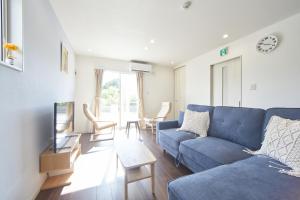 瀬底にあるvilla PILINAのリビングルーム(青いソファ、椅子付)