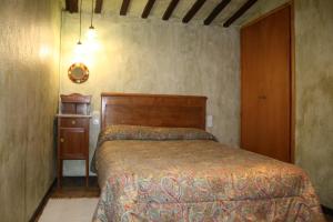 1 dormitorio con cama y cabecero de madera en Cal Cisteller, en Gironella