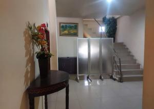 a room with a table and stairs with a refrigerator at Hotel Mulia Kendari Mitra RedDoorz in Pipulu +23 photos