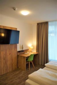 una camera d'albergo con scrivania e TV di Maiers Hotel Parsberg a Parsberg