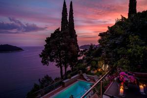 uma vista para o oceano a partir de uma casa com piscina em Luxury Beachfront Villa Dubrovnik Palace with private pool and jacuzzi by the beach in Dubrovnik em Dubrovnik