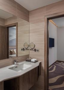 uma casa de banho com um lavatório e um espelho em Sensory Park Urban Hotel em Phnom Penh