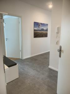 a white room with a painting on the wall and a door at Seeblick Strandgold, exklusive Wohnung mit Meerblick in Wangerooge