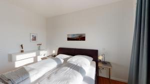 - une chambre dotée d'un lit avec des draps blancs dans l'établissement Seeblick Strandgold, exklusive Wohnung mit Meerblick, à Wangerooge