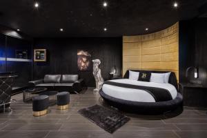 a bedroom with a large bed and a couch at H Hotel & SPA - Adults Only in St. Julianʼs