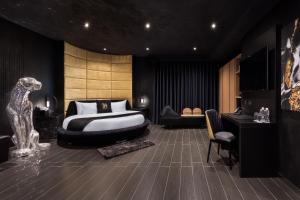 a bedroom with a bed and a desk and a chair at H Hotel & SPA - Adults Only in St. Julianʼs