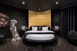 a bedroom with a bed and a statue in it at H Hotel & SPA - Adults Only in St. Julianʼs