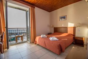 a bedroom with a bed and a large window at Sea Horse in Mythimna