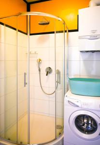 a shower stall in a bathroom with a washing machine at Modern Suite Naschmarkt in Vienna