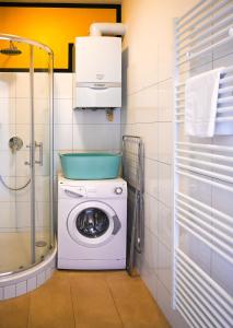 a washing machine in a bathroom with a shower at Modern Suite Naschmarkt in Vienna