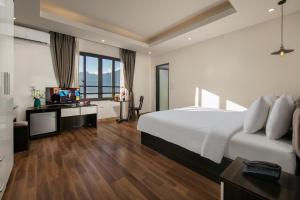 een slaapkamer met een bed en een bureau met een televisie bij Sapa Valley view hotel in Sa Pa
