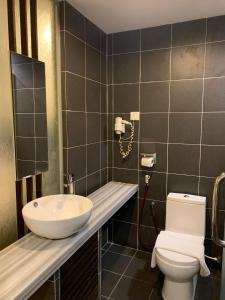 a bathroom with a white toilet and a sink at T+ Hotel Sungai Petani in Sungai Petani