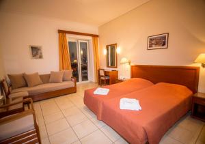 una camera d'albergo con due letti e un divano di Sea Horse a Mythimna