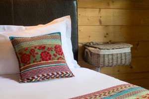 a bedroom with a bed with a pillow and a basket at Auberge La Tomette, The Originals Relais in Vitrac