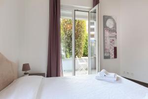 a bedroom with a white bed and a large window at Maraini Apartments by Quokka 360 - strategic location near Lugano station in Lugano