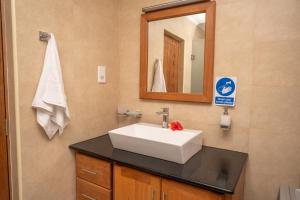 a bathroom with a white sink and a mirror at Kolibri Holiday Apartments in Victoria +37 photos