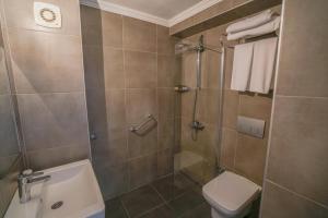 uma casa de banho com um chuveiro, um WC e um lavatório. em Yunus Hotel em Marmaris