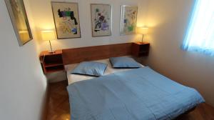 sypialnia z niebieskim łóżkiem i 2 lampami w obiekcie Apartment Rolih w mieście Vantačići