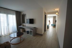 a living room with a table and a couch and a room at Yunus Hotel in Marmaris