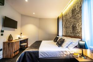 ein Hotelzimmer mit einem Bett und einem TV in der Unterkunft Calma LUXURY Rooms in Split