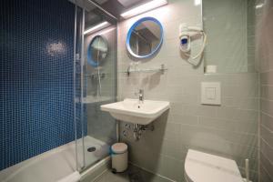 a bathroom with a sink and a toilet and a mirror at Hotel Ivando in Drvenik