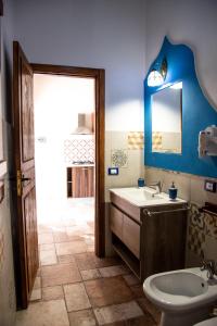 ein Badezimmer mit einem Waschbecken, einem WC und einem Spiegel in der Unterkunft CASE VACANZE I QUATTROVENTI in Lampedusa