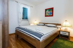 ein Schlafzimmer mit einem Bett mit zwei Hunden darauf in der Unterkunft Apartment Adria 3 in Malinska