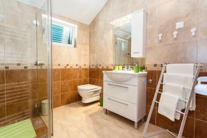a bathroom with a toilet and a sink and a shower at Apartment Adria 3 in Malinska +29 photos