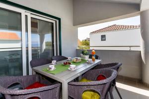 a table and chairs with food on a balcony at Apartment Adria 3 in Malinska